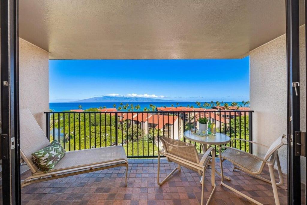 a balcony with a table and chairs and the ocean at Kaanapali Shores 940 · KS 940 Top Floor Studio w Ocean Views AC in Lahaina