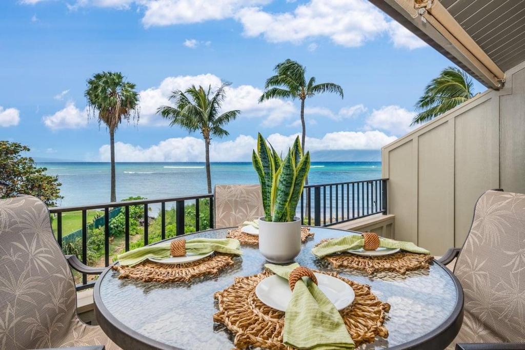 a table on a balcony with a view of the ocean at Kahana Village 2 · KHV 2 Direct Oceanfront 2BD Condo Steps to Be in Kahana