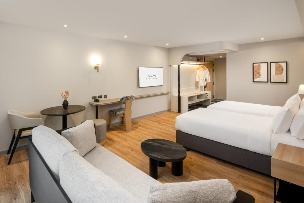 A spacious-looking room combining a king bed, sofa seating, dining table and desk.
