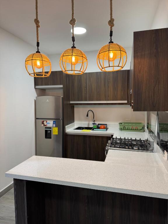 a kitchen with three lights hanging over a counter at Hospedaje Tena Matrimonial in Tena