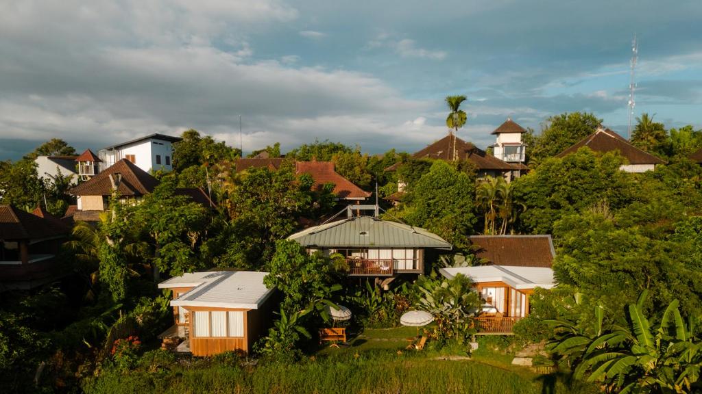 un groupe de maisons sur une colline avec des arbres dans l'établissement Grün Ubud, à Ubud