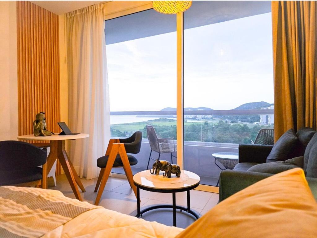 un soggiorno con letto e una grande finestra di Loft BelloHorizonte vista al mar y reserva cabo tortuga a Santa Marta
