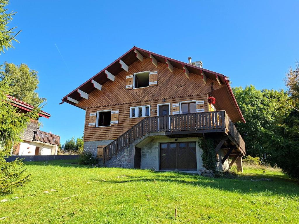 a house with a gambrel roof on a green field at Chalet au calme pour 10 pers, proche centre et activités - FR-1-834-9 in Les Rousses