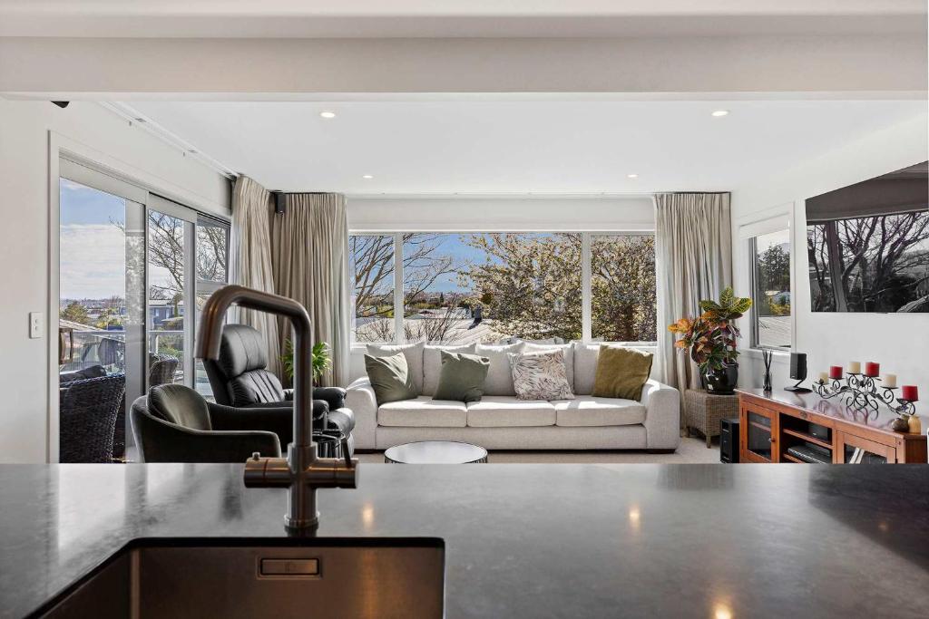 a kitchen and living room with a couch and a sink at Rainbow Haven Where family time meets Lake time in Coffs Harbour