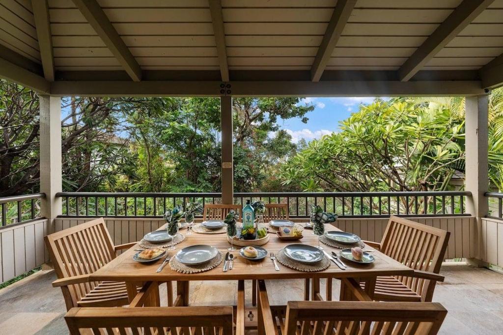 a wooden table with chairs on a porch with at Wailea Ekolu 1604 · WE 1604 Wailea 2BD Condo w AC Pool Near Beac in Kihei