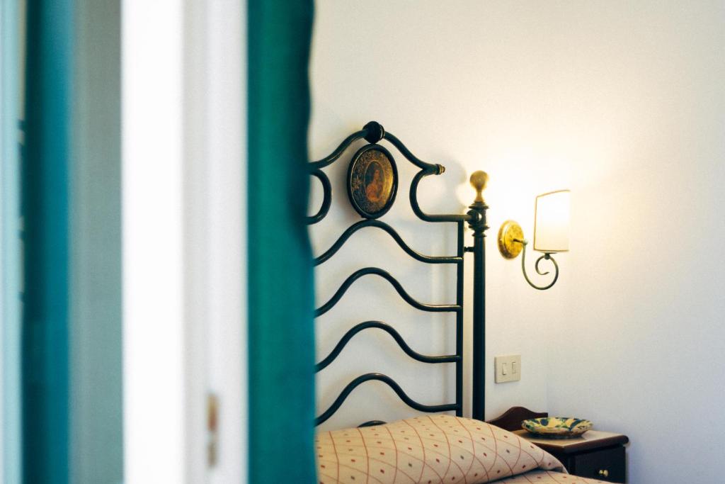 a bed with a black and white headboard and a lamp at Villino Eleonora in Parghelia