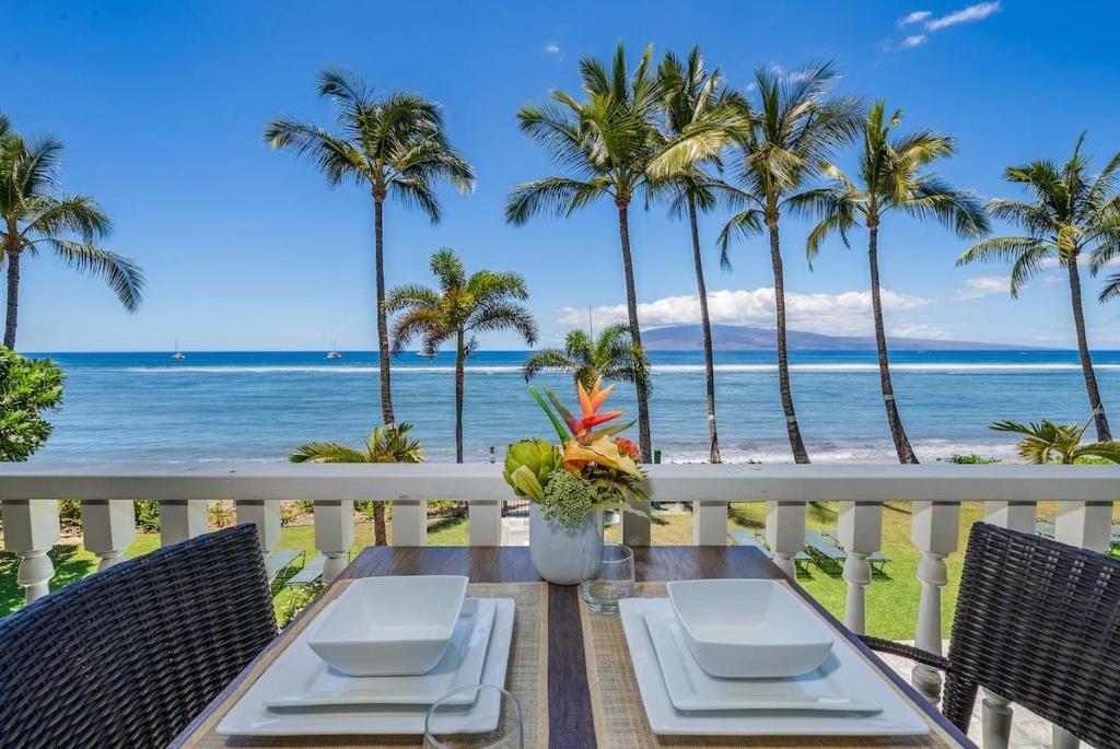 Una mesa en un balcón con vista a la playa. en Lahaina Shores 215 · LS 215 Direct Beachfront Views Remodeled St, en Lahaina