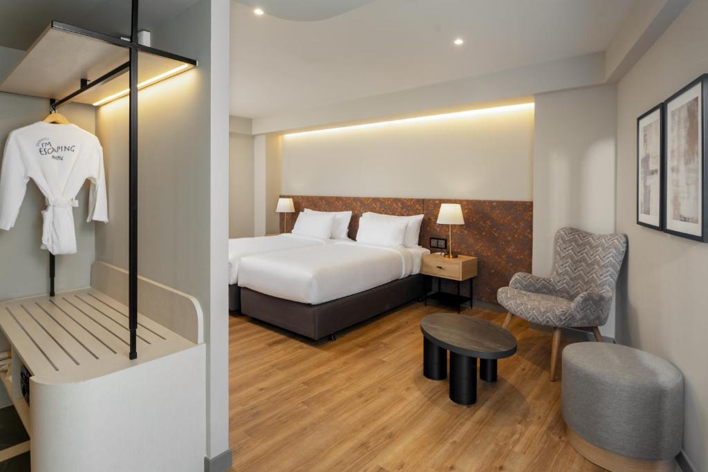 A furnished bedroom with a large bed, lounge chair, ottoman, coffee table and open hanging area.