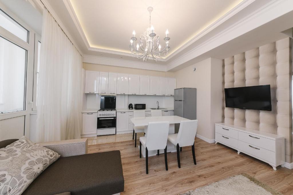 a kitchen and dining room with a table and chairs at The Base Apartments in Chişinău