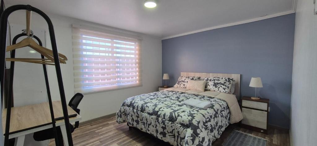 a bedroom with a bed and a window at Hostal Milaris in Calama
