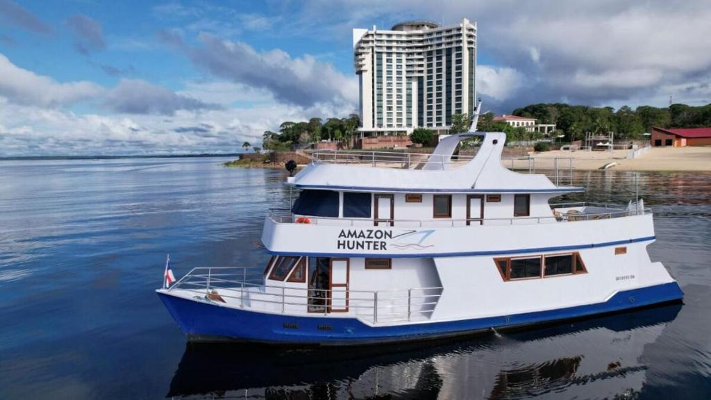 een boot in het water voor een hotel bij Iate AmazonHunter in Manaus