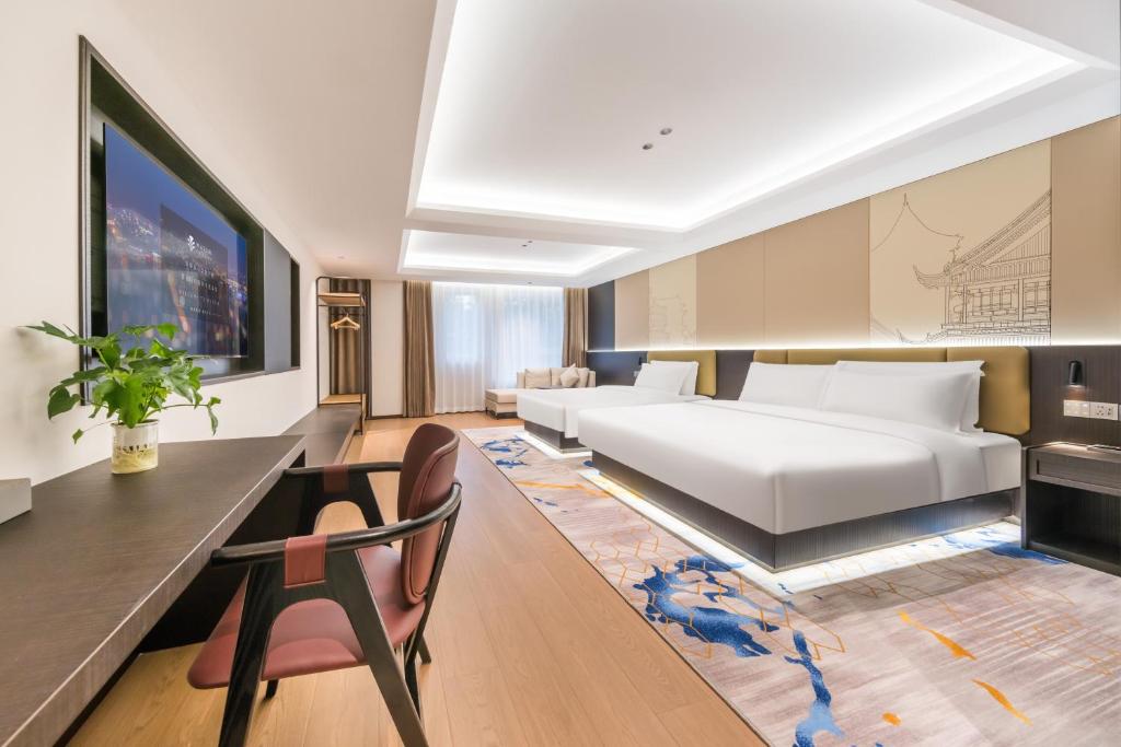 a bedroom with a large bed and a desk and chair at Wanxin Zhige Hotel - Beijing South Railway Station Liujiayao Subway Station in Beijing