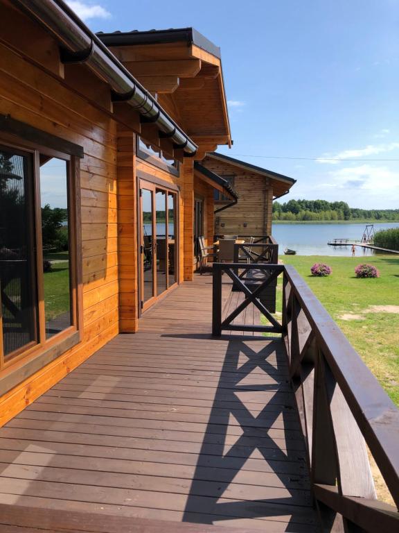 a wooden walkway to a cabin with a lake in the background at Берег Світязя 3 in Svityazʼ