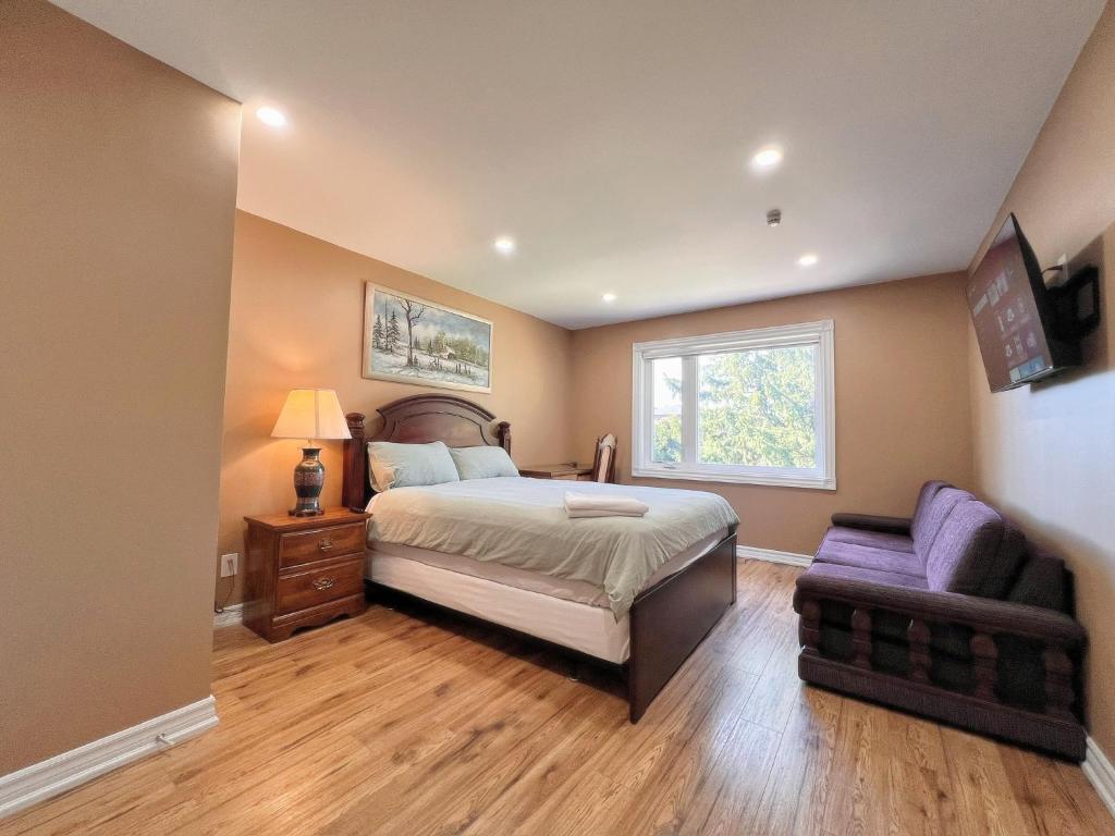 a bedroom with a bed and a chair and a window at Spacious Rooms with Bath Near Wonderland & Vaughan Mills Mall in Vaughan