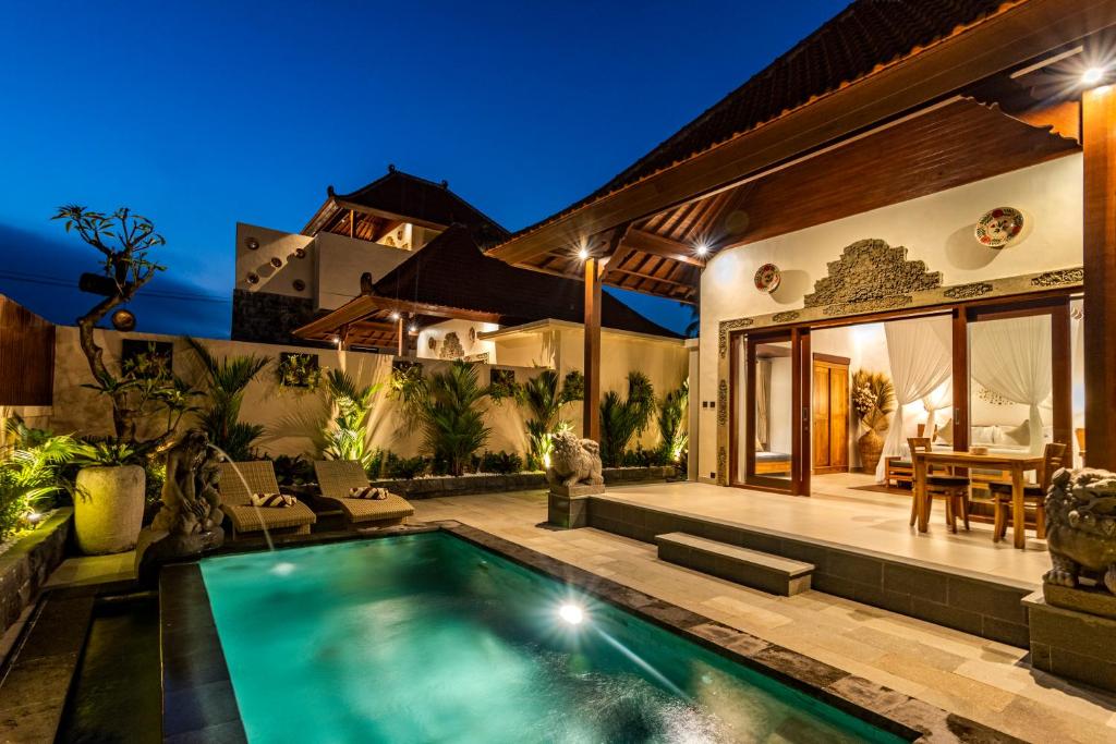 una casa con piscina en el patio trasero en Kori Sebatu Villa by Dhananjaya Hospitality, en Gianyar