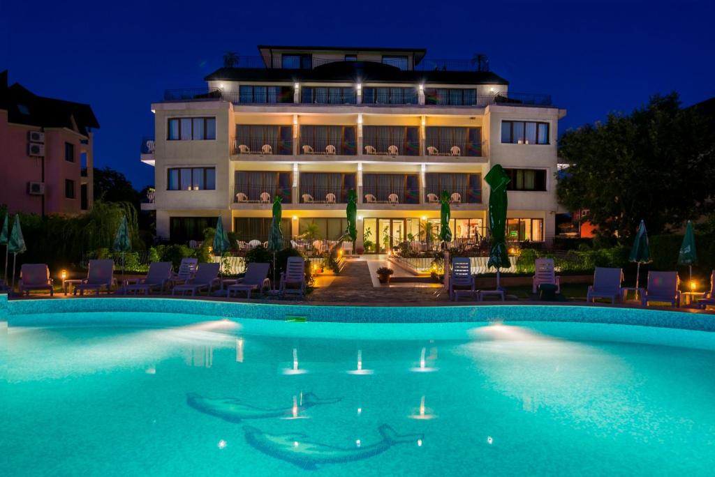 uma piscina em frente a um hotel à noite em Atlant Hotel em St. Constantine and Helena