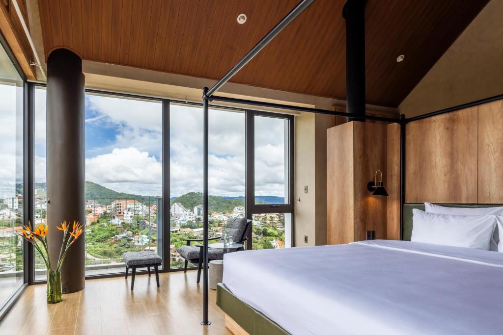 a bedroom with a bed and a large window at Là Yên Retreat in Ấp Ða Lợi