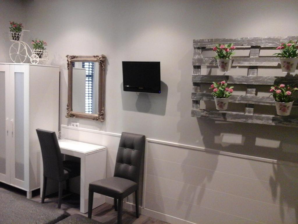 una sala d'attesa con scrivania e TV a parete di Hostal Don Alfonso a Madrid