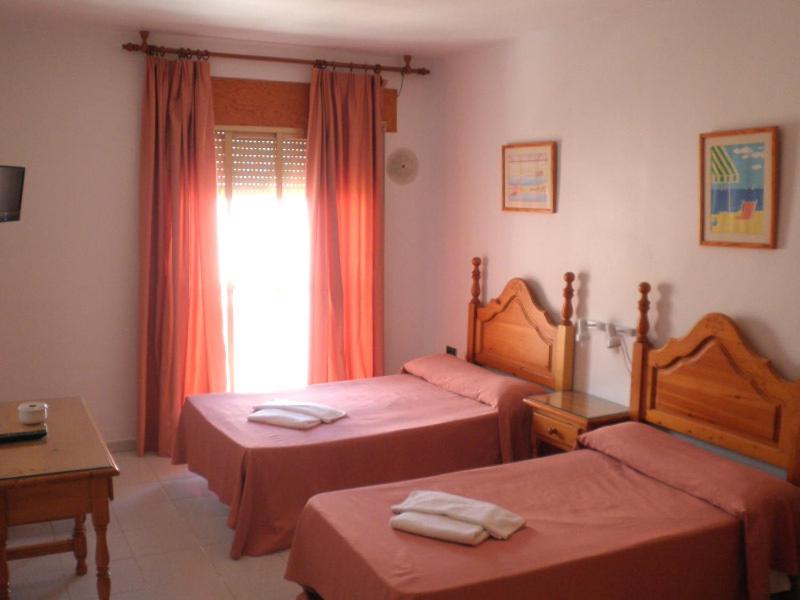 a hotel room with two beds and a window at Pensión Felipe in Carboneras
