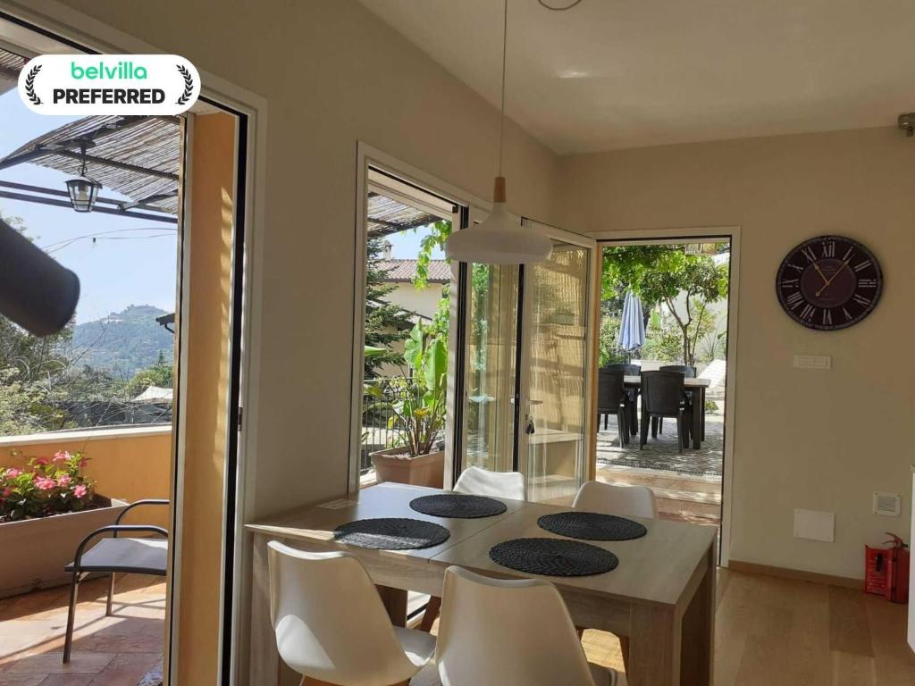 a dining room with a table and chairs and a clock at Chic Coastal Hill Escape in Ventimiglia