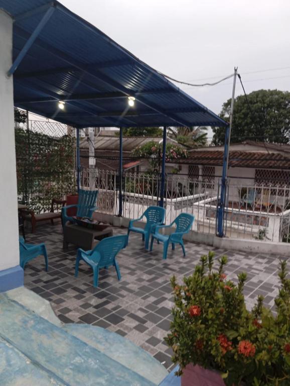 a patio with blue chairs under a blue canopy at Casa Santorini in Cartagena de Indias