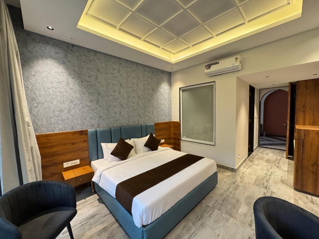 a bedroom with a large bed and a flat screen tv at Nazaara Hills Retreat in Thūr