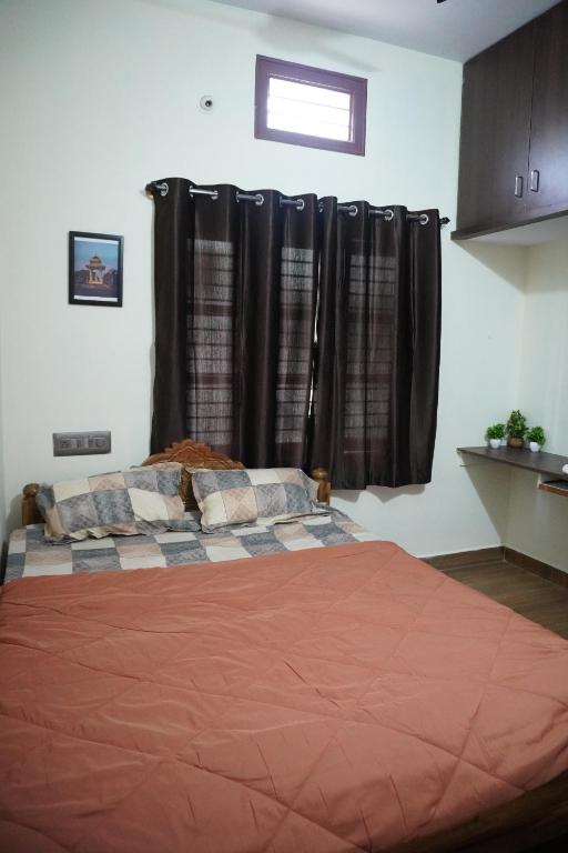 a bedroom with a large bed with black curtains at Sihi 3bhk Homestay in Jāmb