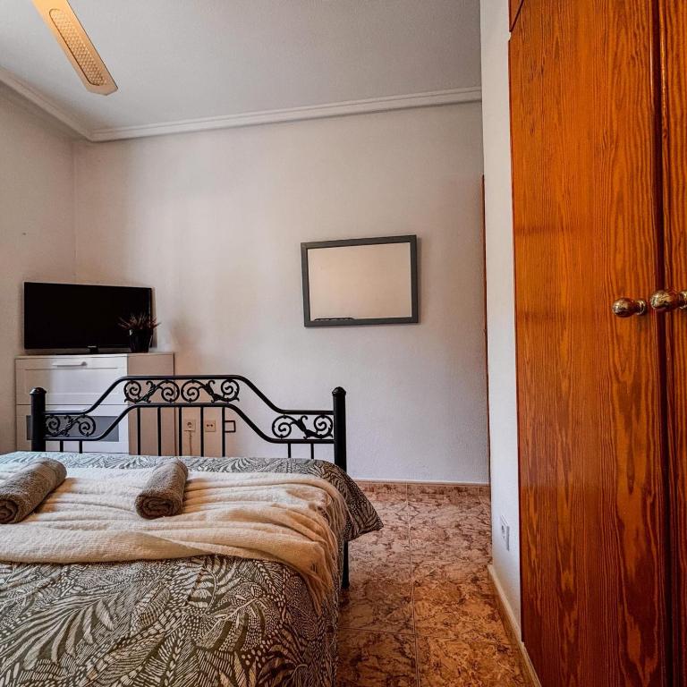 ein Schlafzimmer mit einem Bett und einem Fernseher an der Wand in der Unterkunft Casa Villamartin in Villacosta