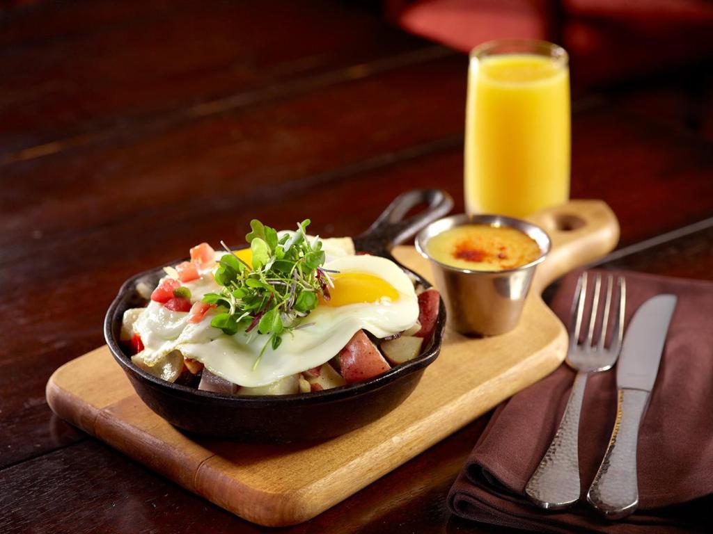 フォートワースにあるオムニ フォート ワース ホテルの木のトレイの上に卵が乗った食べ物のボウル