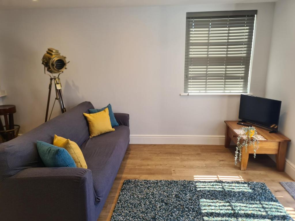 a living room with a couch and a television at Number 10 - Stunning brand new house - sleeps 6 - free parking in Topsham