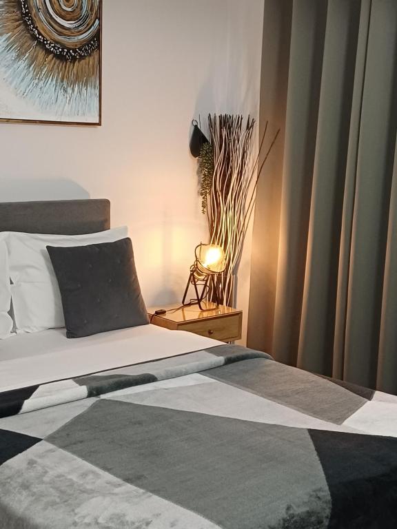 a bedroom with a bed and a lamp on a table at Rafina's BLUE HEART! Steps from the beach,2 min walk - WALK to Rafina main square 10 min, and Port about 15 min walk ! Ideal vacation base! in Rafina