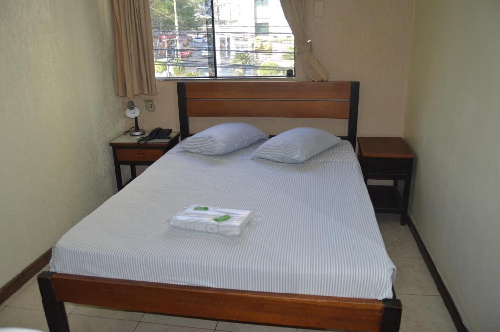 a bedroom with a bed with two pillows on it at Hotel Aeroporto de Congonhas in Sao Paulo