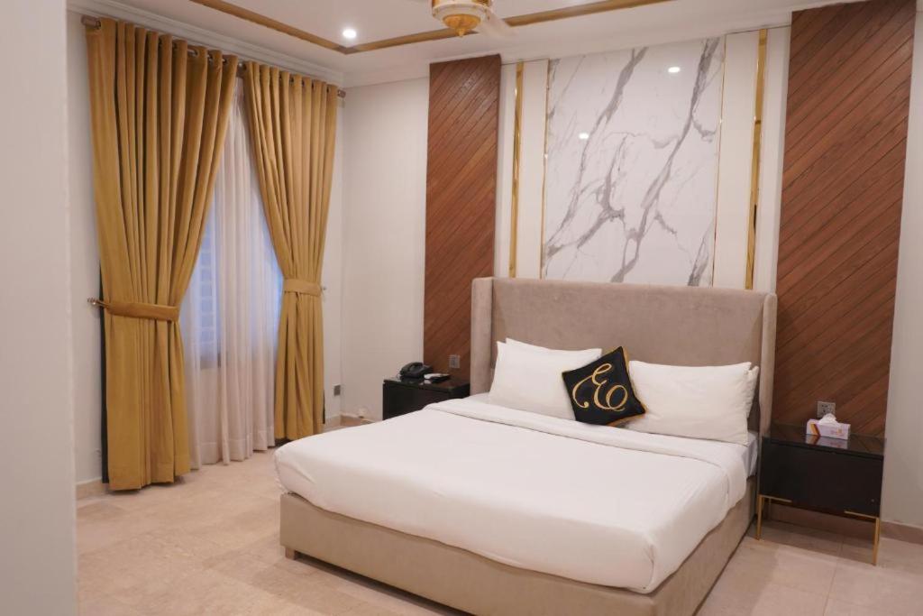 a bedroom with a white bed and a large window at Envoy Express, Islamabad in Islamabad