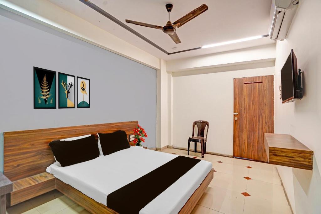 a bedroom with a bed and a tv and a chair at Collection O Kadodara Bus Terminal Formerly Hotel Rudra in Balesar