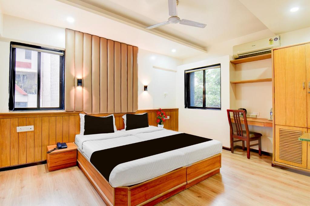 プネにあるSuper Townhouse Viman Nagar Business Stay Formerly Silver Crestのベッドと机のある寝室