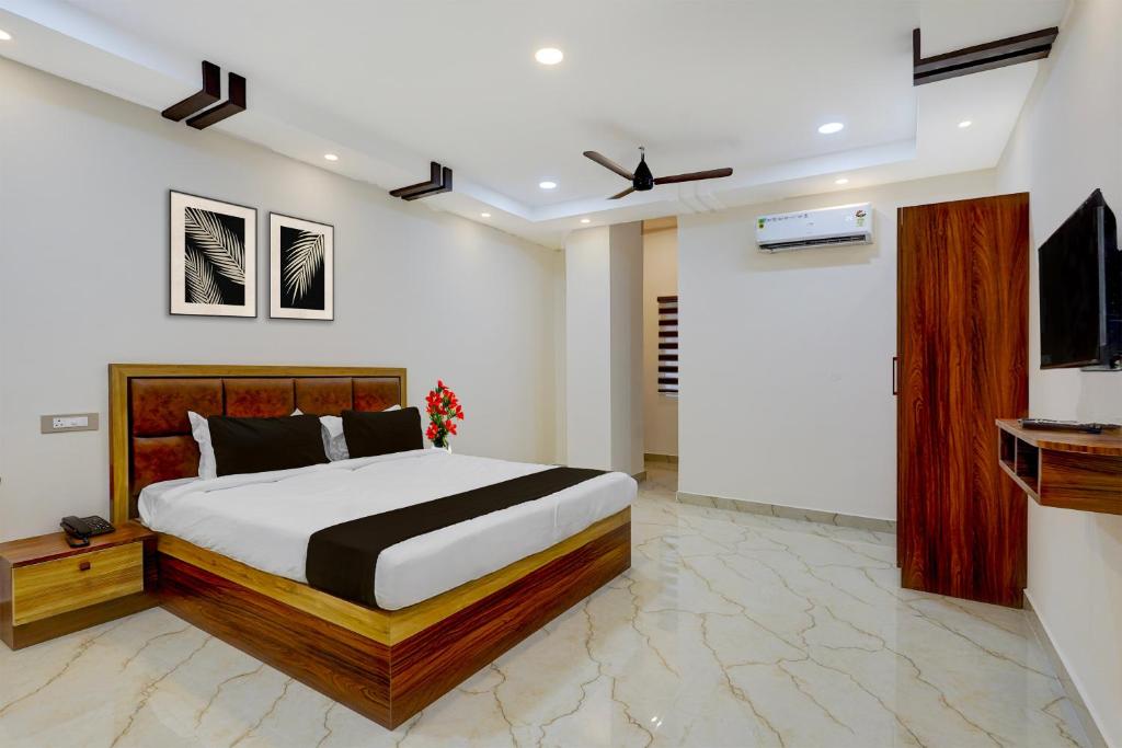 a bedroom with a bed and a flat screen tv at Townhouse Guduvancheri Junction Formerly Zafe Commercial in Madambakkam