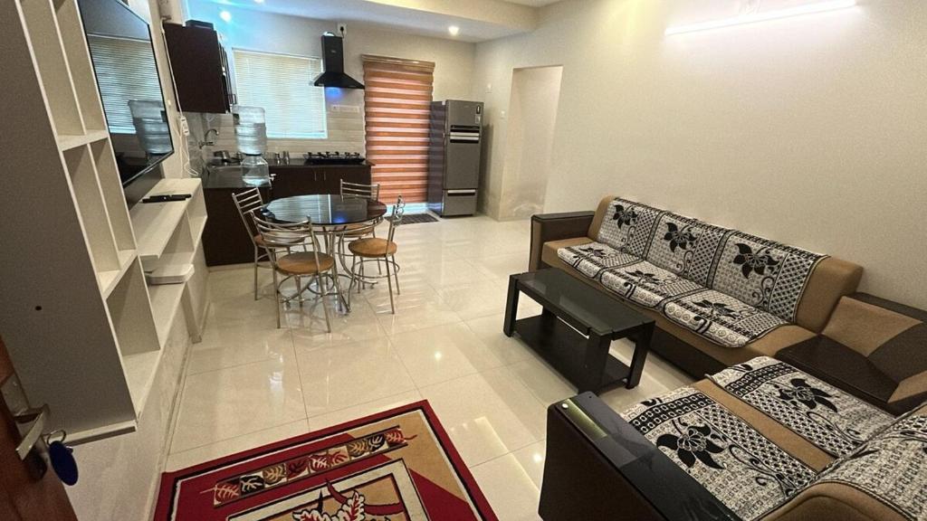 een woonkamer met een bank en een tafel bij Le divine in Guruvāyūr