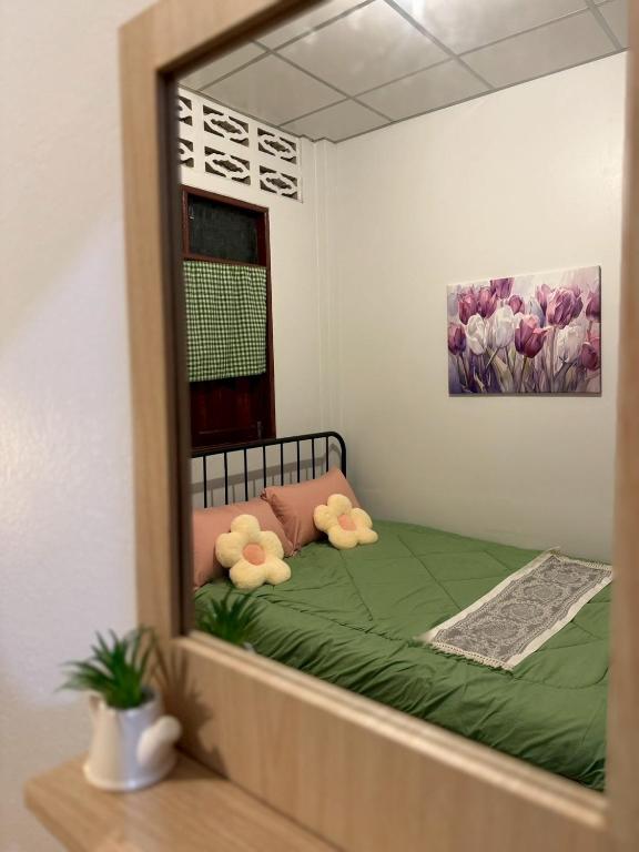 a mirror reflection of a bed in a bedroom at Baan Suan Chay Nam Homestay Amphawa in Amphawa