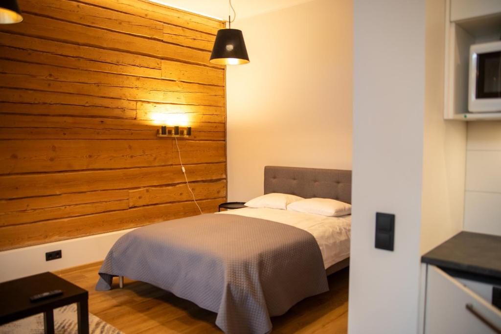 Un dormitorio con una cama y una pared de madera. en Sweet Escape in Rakvere Center, Perfect for Two, en Rakvere
