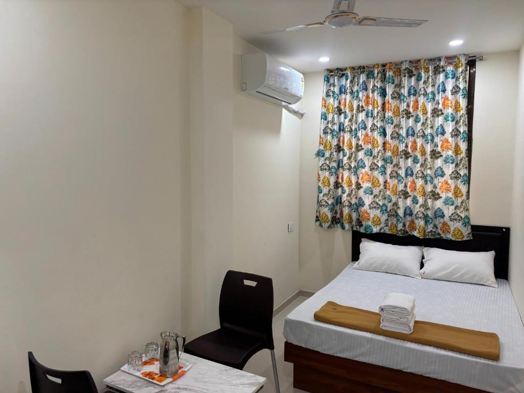 Una pequeña habitación con una cama y una ventana. en Hotel O Elegance Inn, en Sopāra