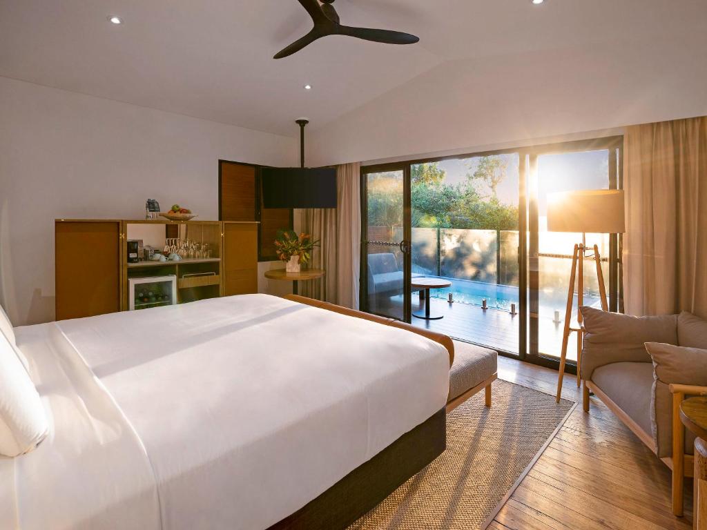 una camera da letto con un letto grande e un soggiorno di Mercure Darwin Airport Resort a Darwin