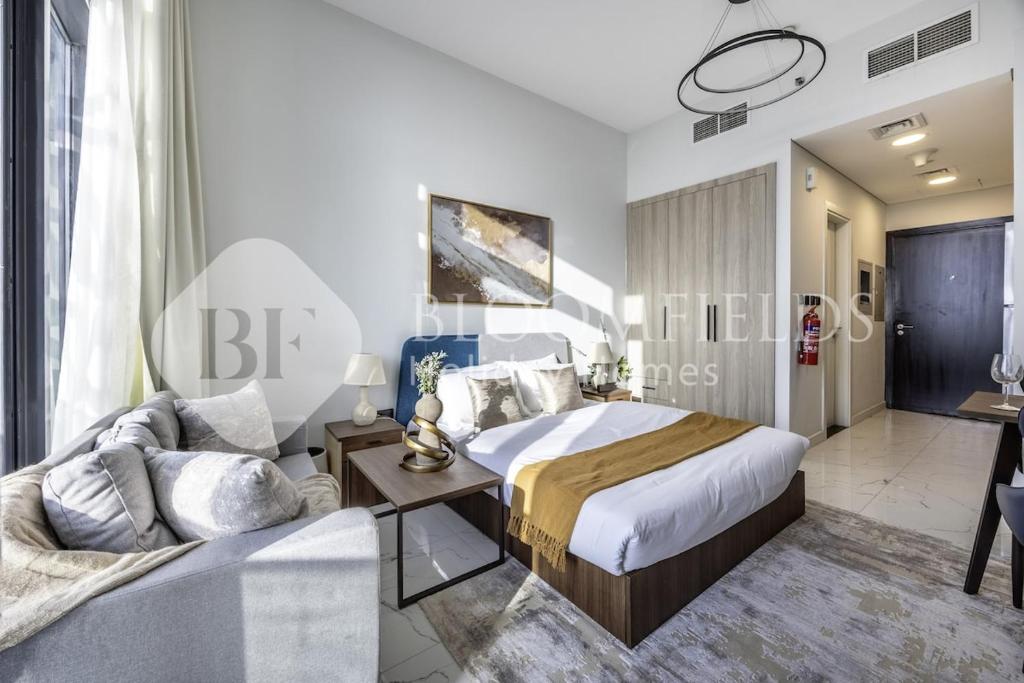 a bedroom with a bed and a couch at Bloomfields Casual Stu in The Gate in Abu Dhabi
