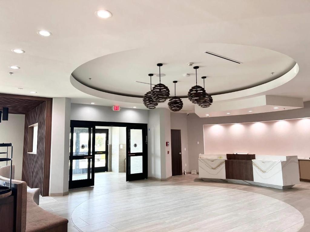 a lobby with two chandeliers hanging from a ceiling at Cambria Hotel Northlake Conference Center - Roanoke in Northlake
