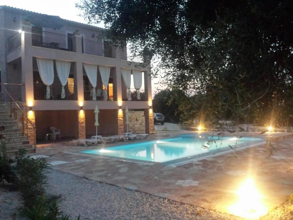 ein Schwimmbad vor einem Gebäude in der Nacht in der Unterkunft Villa Androniki in Longós