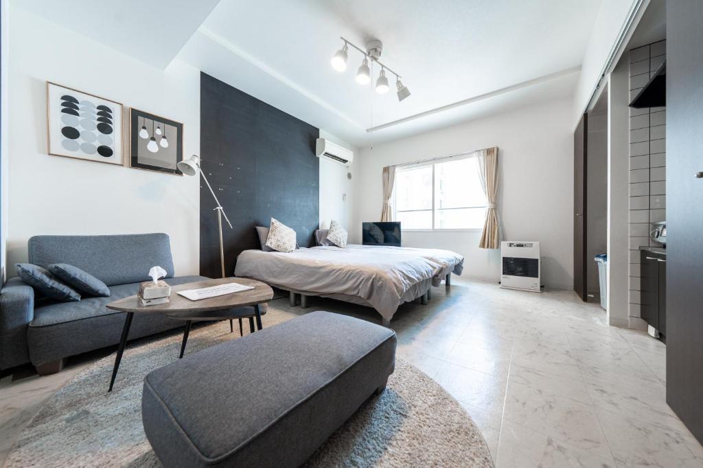 札幌市にあるYELLOWのベッドとソファとテーブルのある寝室