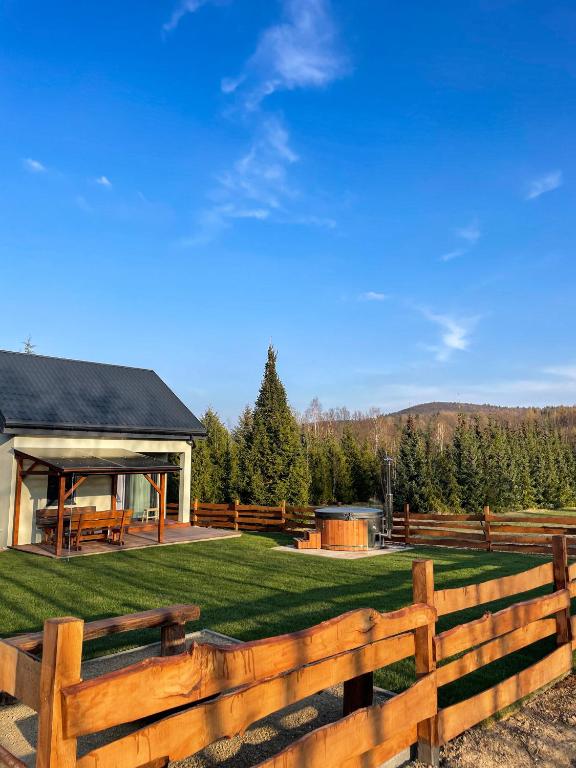 a wooden fence in front of a backyard with a gazebo at Domek Na Miodowej in Sulistrowiczki