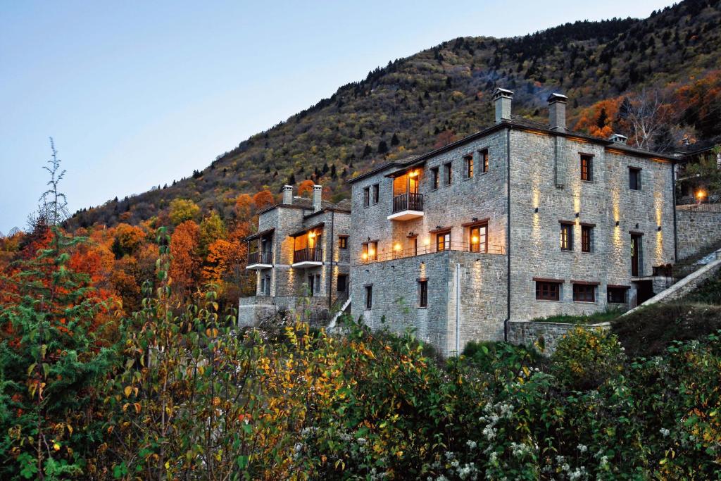 a large stone building on the side of a hill at Hotel Athina in Elati