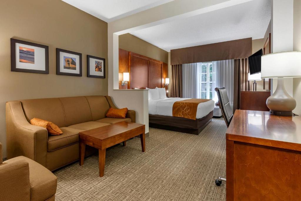 a hotel room with a couch and a bed at Comfort Suites in Marquette