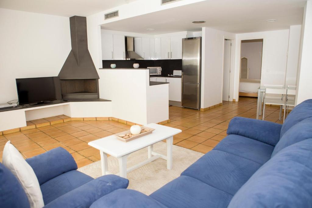 カダケスにあるMimoses Apartamentsのリビングルーム(青いソファ、テーブル付)