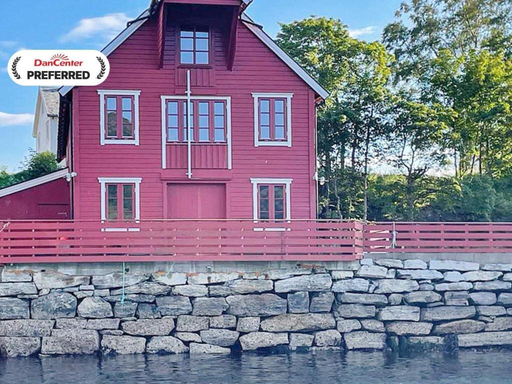 a red house sitting on top of a stone wall at 12 person holiday home in Selje-By Traum in Selje